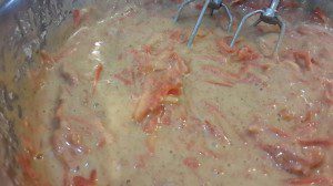Adding grated carrots to the carrot cake batter